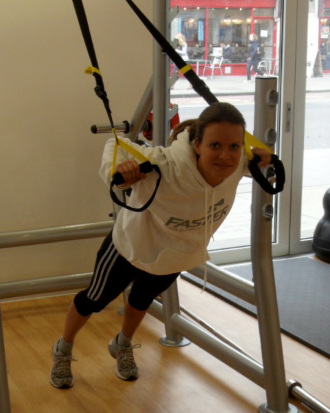 A trainer in a FASTER hoodie doing a suspension fly